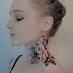 a woman with a flower tattoo on her neck