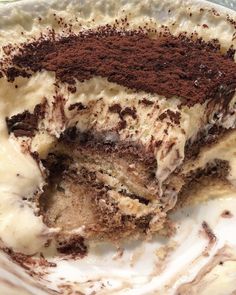 a close up of a piece of cake on a plate with icing and chocolate