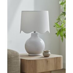 a white lamp sitting on top of a wooden table