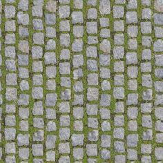 an aerial view of cobblestone pavement with green grass