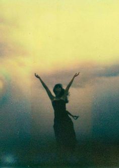 a woman standing in the water with her arms up