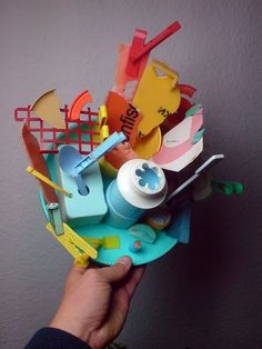 a person is holding a bunch of toys in their hand and it looks like they are made out of paper