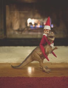 an elf riding on top of a toy dinosaur