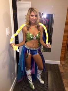 a woman is dressed up in costume and holding a snake around her waist while posing for the camera