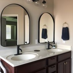 a bathroom with two sinks and mirrors in it