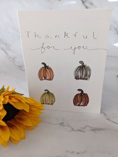 a card that says thank you with three pumpkins on it next to a sunflower