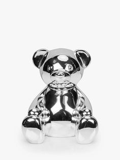 a silver teddy bear sitting on top of a white surface