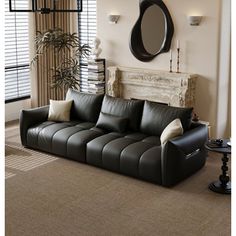 a living room with a black leather couch and mirror on the wall next to it