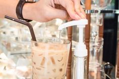 a person is filling a glass with liquid