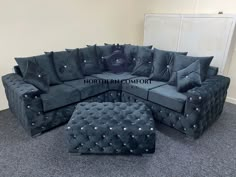 a large black sectional couch with silver studding on the back and footrests