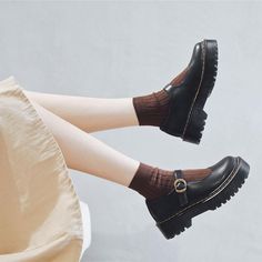 a woman's legs with black shoes and brown socks