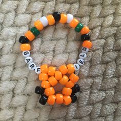 an orange and black beaded bracelet with letters on it