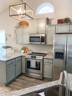 a kitchen with stainless steel appliances and granite counter tops, along with an island in the middle