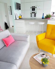 a living room filled with furniture next to a kitchen