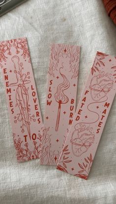 three red bookmarks sitting on top of a white cloth