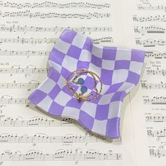 a purple and white checkered plate sitting on top of sheet music