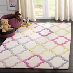 a white rug with pink, blue and yellow trellis on it in a living room