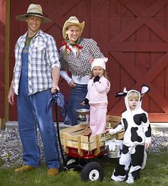 three people dressed in costumes standing next to a child on a wagon with a cow