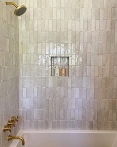 a white bath tub sitting next to a shower head