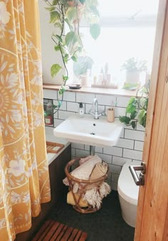 a bathroom with a toilet, sink and shower curtain in it's window sill