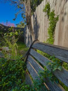 a wooden bench sitting next to a fence