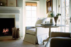 a living room filled with furniture and a fire place in front of a large window