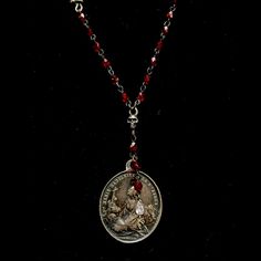 Paired with Ruby Red Austrian Crystals, the Mary Magdalene at la Sainte-Baum shows a contemplative Mary Magdalene looking toward the heavens with the mountains of Baum in the background. A skull sits to her right reminding us of our mortality and memorializing her feast day on on July 22nd. Small Sterling Silver Momento Skulls are interwoven on her Ruby Red chain to remind us that love like life is fleeting. A small crowned Sterling Silver Sacred Heart sits at the center and can be worn in the c St Michael Necklace, Angelic Realm, Mary Magdalene, Saint Michael, A Skull, Lost Wax Casting, Moon Glow, The Heavens, Pearl Strands