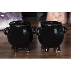 two black pots sitting on top of a wooden table