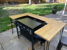 an outdoor bbq table with two grills on it