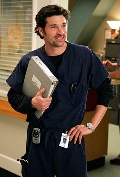 a man in scrubs holding a laptop computer