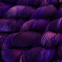 purple skeins of yarn are stacked on top of each other in this close up photo