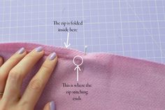 a woman's hand is stitching on the fabric