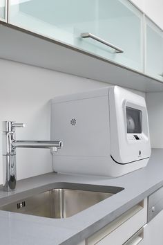 a white machine sitting on top of a counter next to a sink