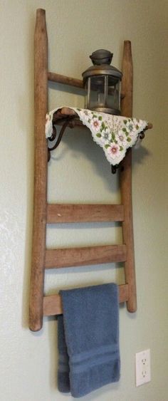 a wooden ladder hanging on the wall next to a towel rack with a tea kettle