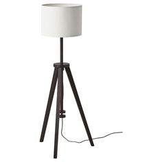 a floor lamp with a white shade on it's base and wooden tripod legs