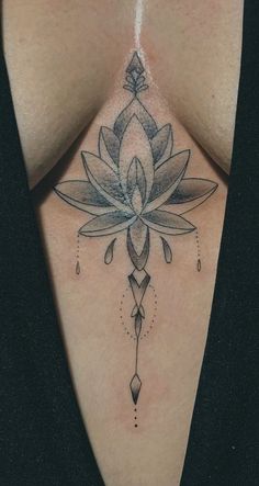 a woman's chest with a lotus tattoo on her left side and an arrow in the center