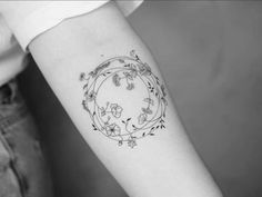 a black and white photo of a woman's arm with a flower tattoo on it