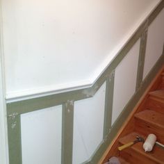 the stairs are being painted white with green trim and some tools on the floor next to them