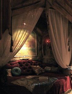 a canopy bed with curtains over it in a bedroom