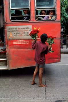 a person standing next to a bus with flowers on it