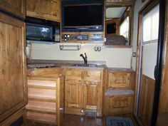 a kitchen with wooden cabinets and granite counter tops in an rv or motor home that is parked on the side of the road