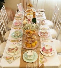 a table with plates, cups and saucers on it is set for a tea party