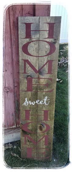 a wooden sign that says sweet home on it's side in front of a door