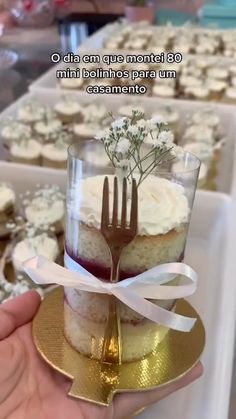 a person holding a cupcake with a fork in it on top of a plate