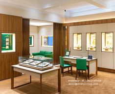 the inside of a jewelry store with green chairs and white tables in front of them