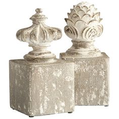 two white vases sitting on top of cement blocks