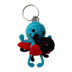 a blue stuffed animal hanging from a keychain on a white background in the shape of an octopus