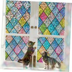 two cats sitting in front of a stained glass window