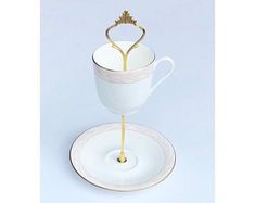 a white and gold cup with a saucer