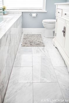 a white toilet sitting next to a window in a bathroom